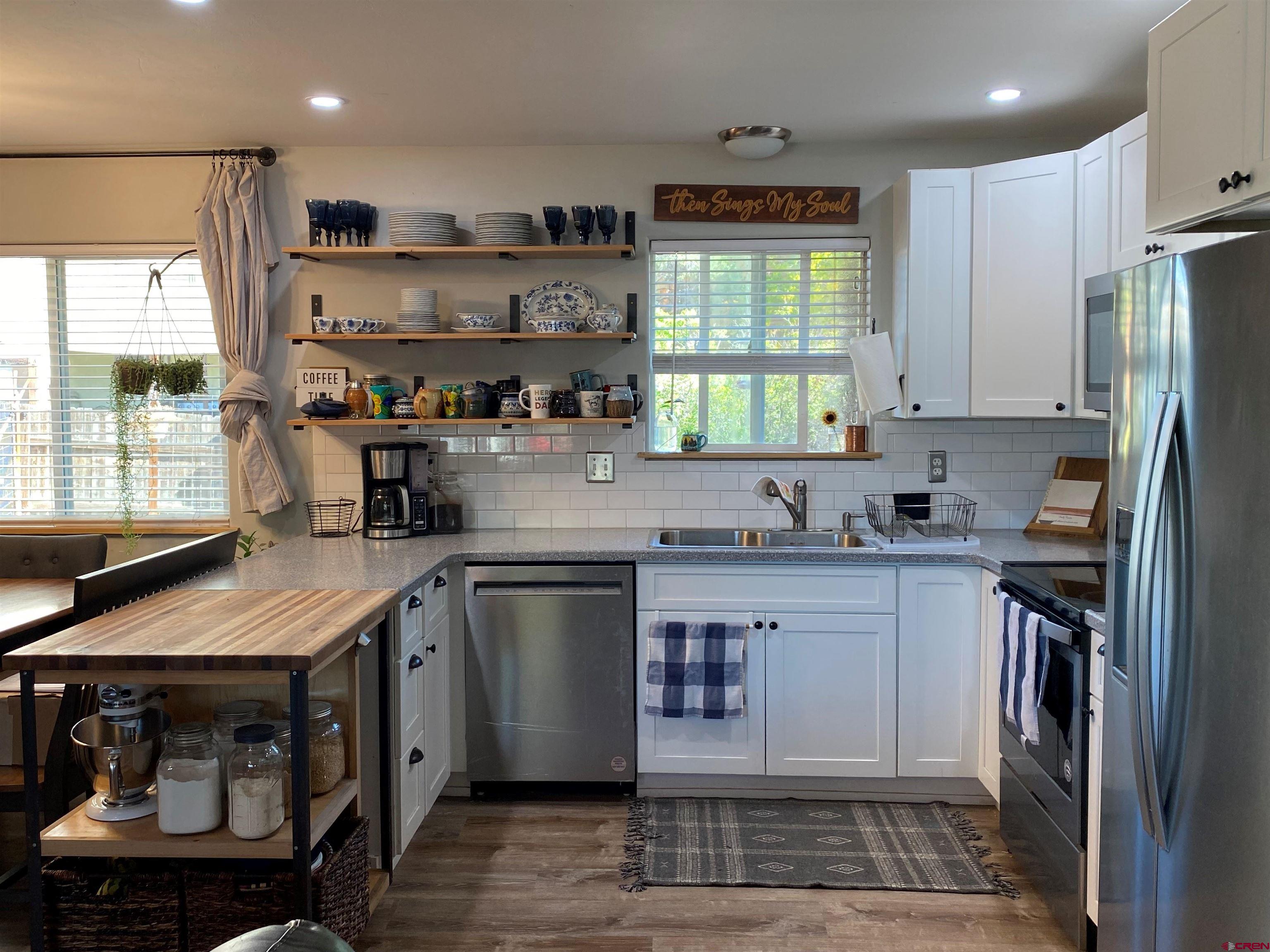 1861 Ouray Drive Montrose, CO 81401 - Photo 3 of 13 a kitchen with stainless steel appliances granite countertop a sink a stove a refrigerator cabinets and a window