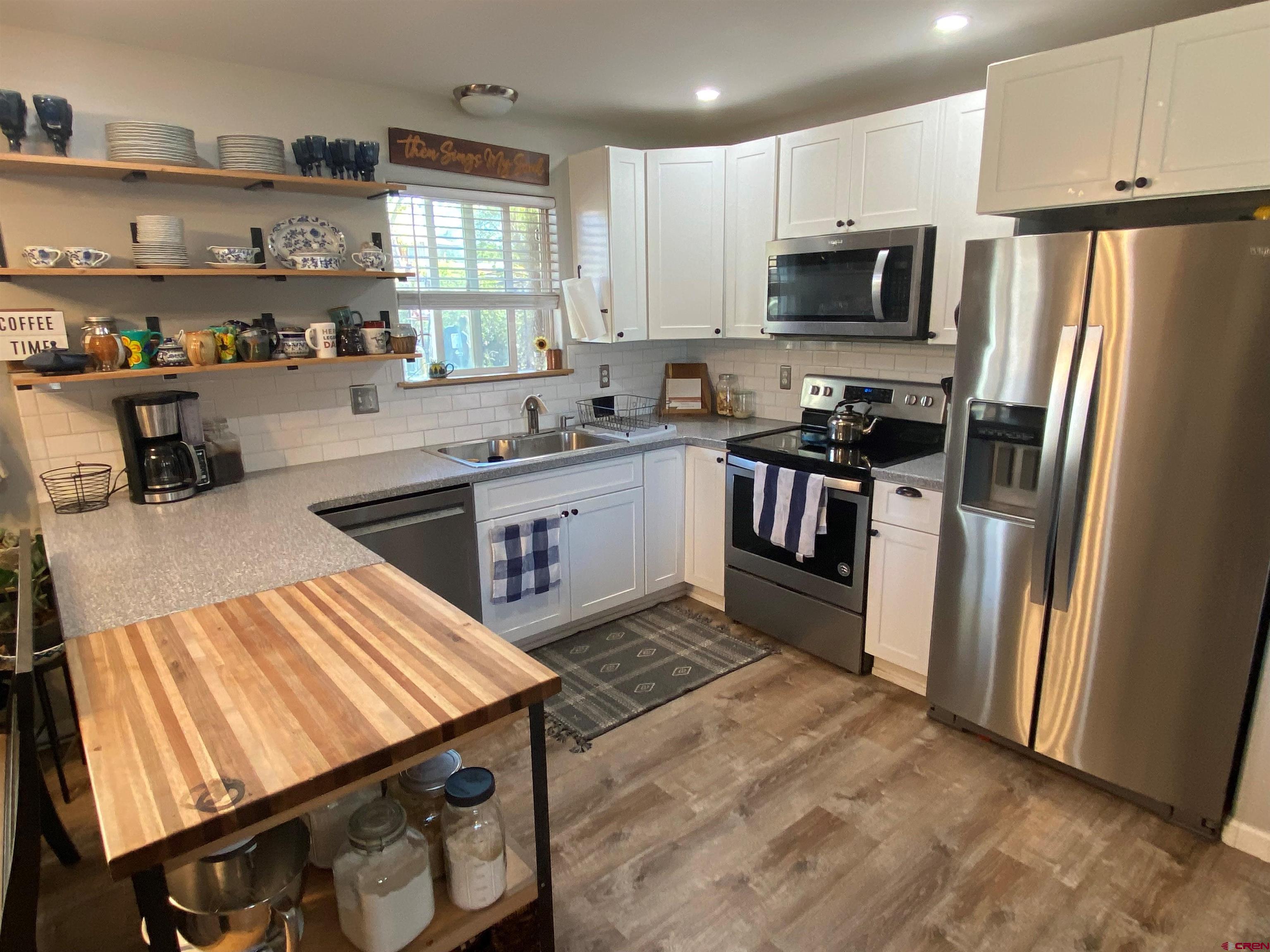 1861 Ouray Drive Montrose, CO 81401 - Photo 4 of 13 a kitchen with stainless steel appliances granite countertop a stove refrigerator sink and cabinets