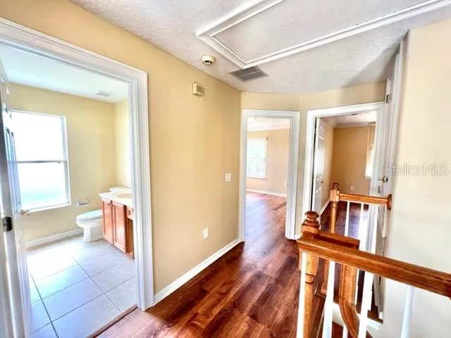a view of a hallway with wooden floor and staircase