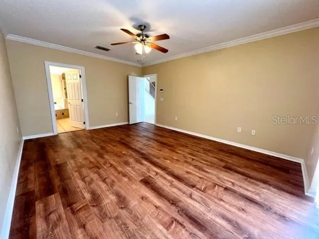 a view of a big room with wooden floor and windows