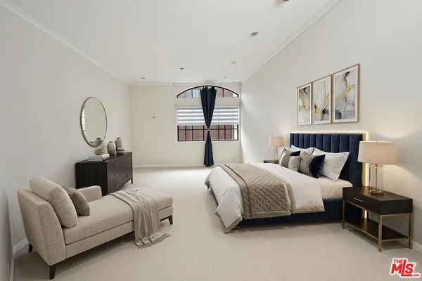 a spacious bedroom with a bed a couch and a window