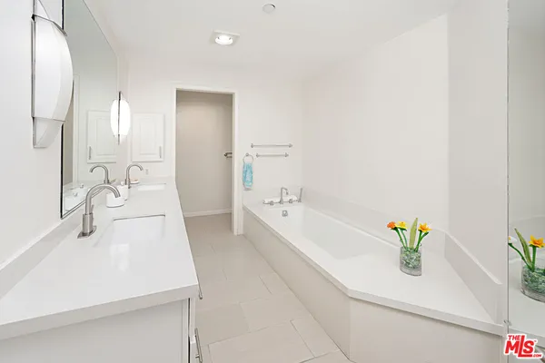 a bathroom with a sink a bathtub and a mirror