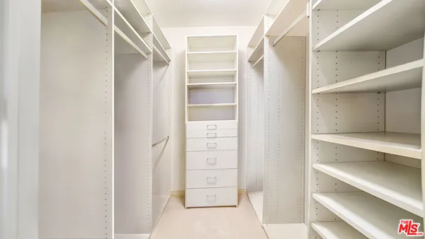 a view of walk in closet with empty racks