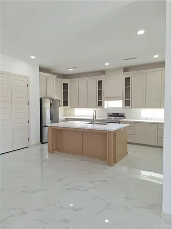 a kitchen with stainless steel appliances granite countertop a refrigerator sink and cabinets