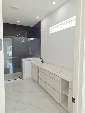a bathroom with a sink mirror and a shower