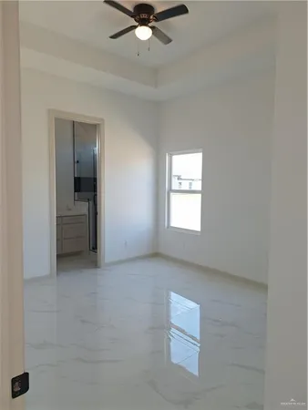 an empty room with a ceiling fan and window