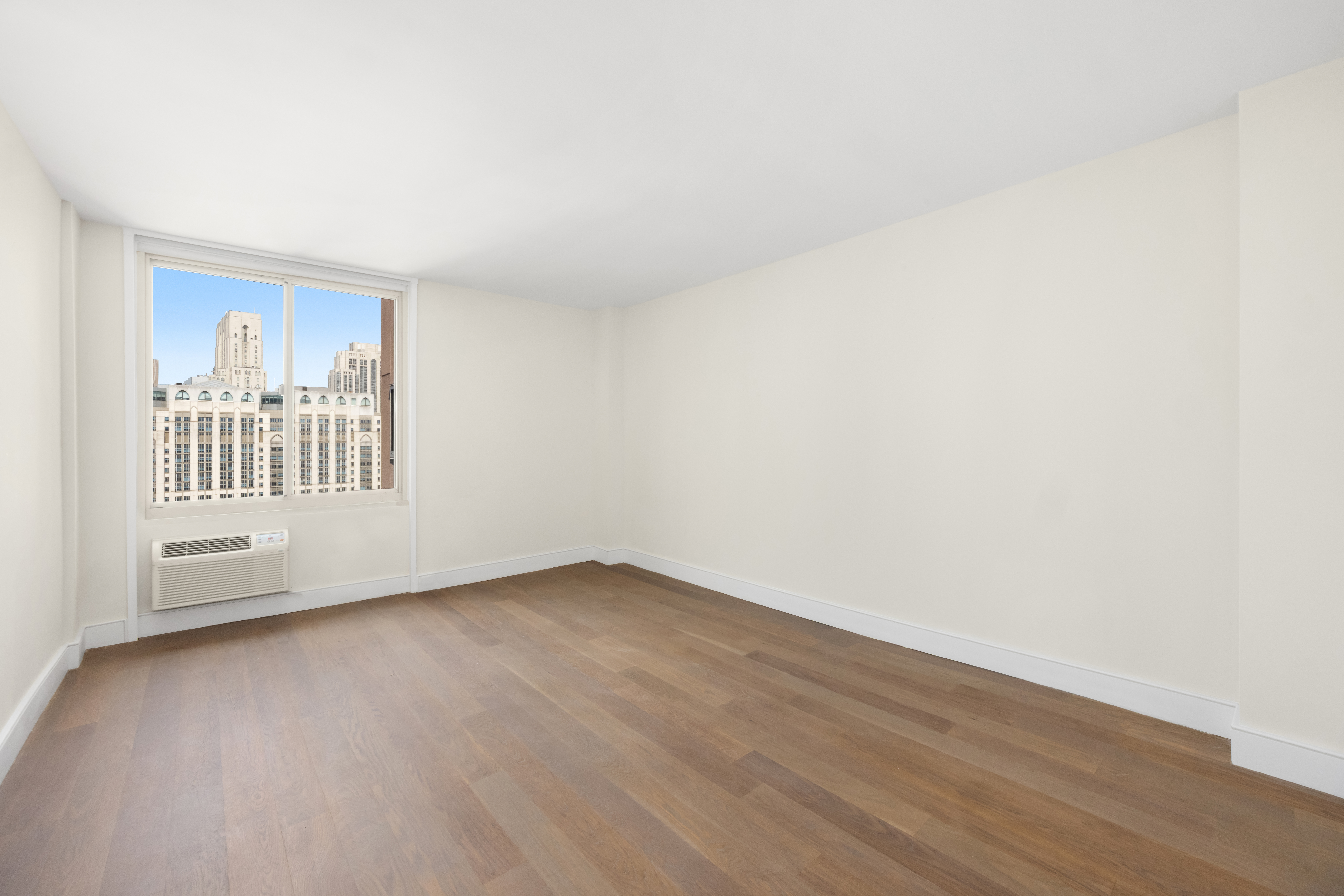 555 Main Street, Unit 1713 Manhattan, NY 10065 - Photo 5 of 9 a view of an empty room with wooden floor and a window