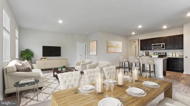 a living room with furniture kitchen view and a wooden floor
