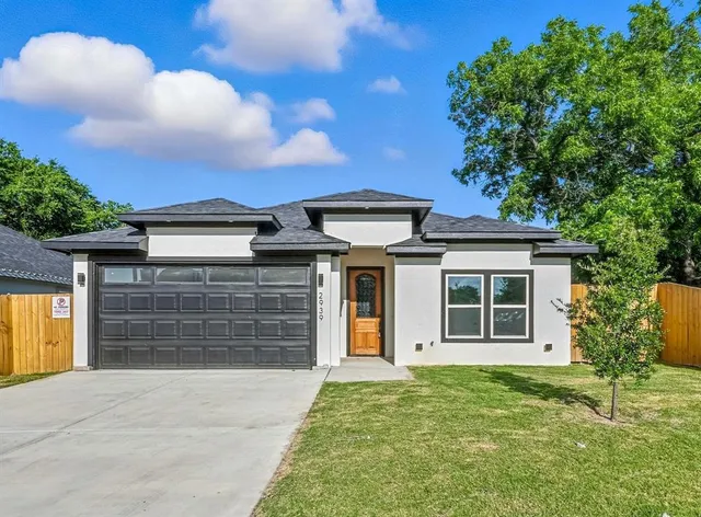 a front view of a house with a yard and garage