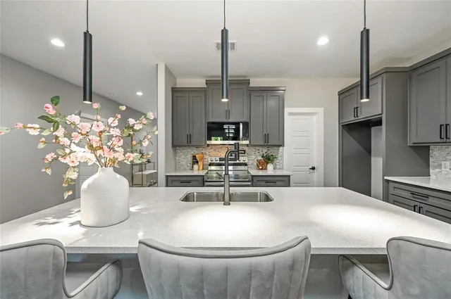 a kitchen with kitchen island stainless steel appliances a sink stove and refrigerator