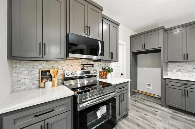 a kitchen with cabinets stainless steel appliances and wooden floor