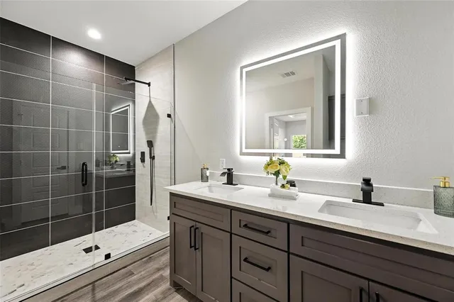 a bathroom with a sink mirror and a shower