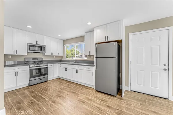 a kitchen with white cabinets and white appliances