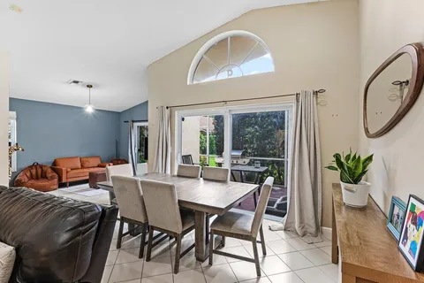 a dining room with furniture and a potted plant