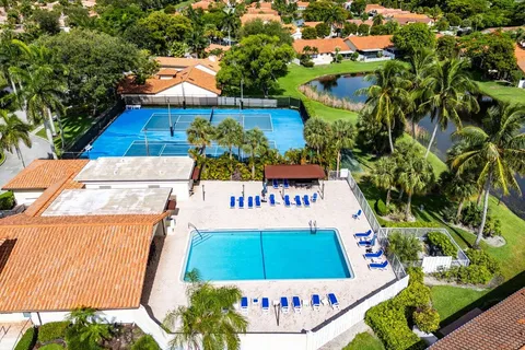 an aerial view of residential building with swimming pool and lawn chairs