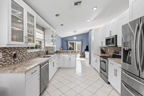 a kitchen with white cabinets and appliances