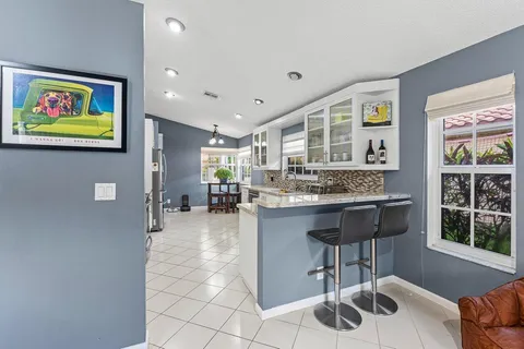 a kitchen with granite countertop a stove a sink a dining table and chairs