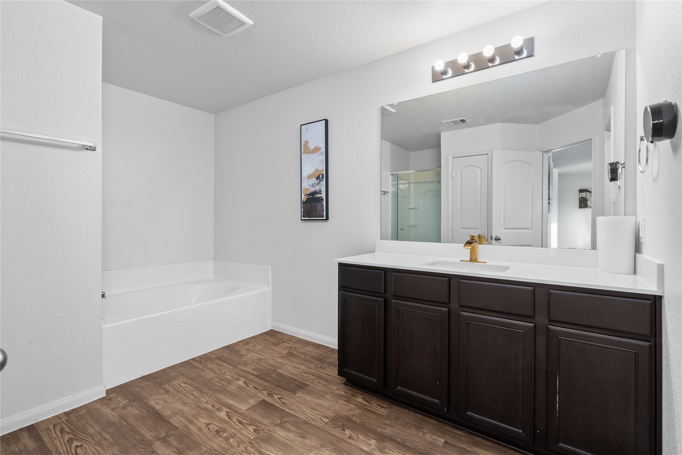 20205 Grover Cleveland Way Manor, TX 78653 - Photo 18 of 26 a bathroom with a tub sink and mirror