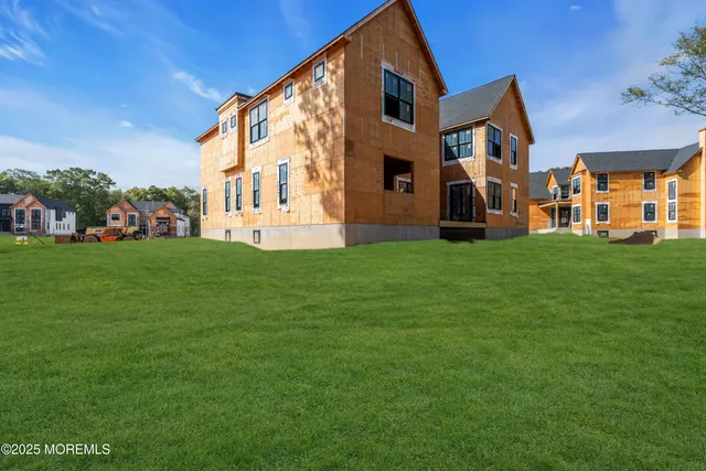 a view of a house with a big yard and large trees