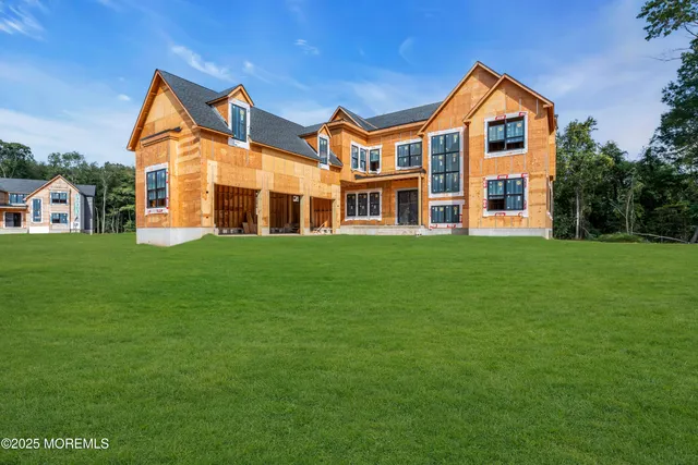 a front view of a house with a yard and trees