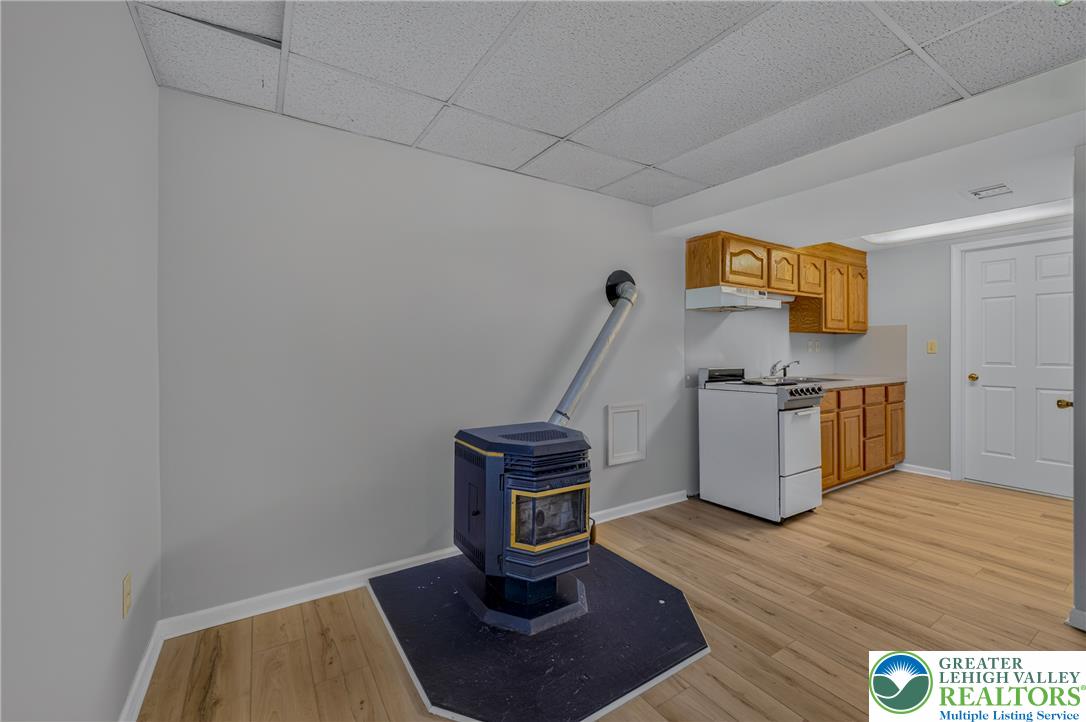 630 Clearfield Road Nazareth, PA 18064 - Photo 75 of 100 A versatile lower-level space features durable wood-look flooring and a cozy freestanding stove.
