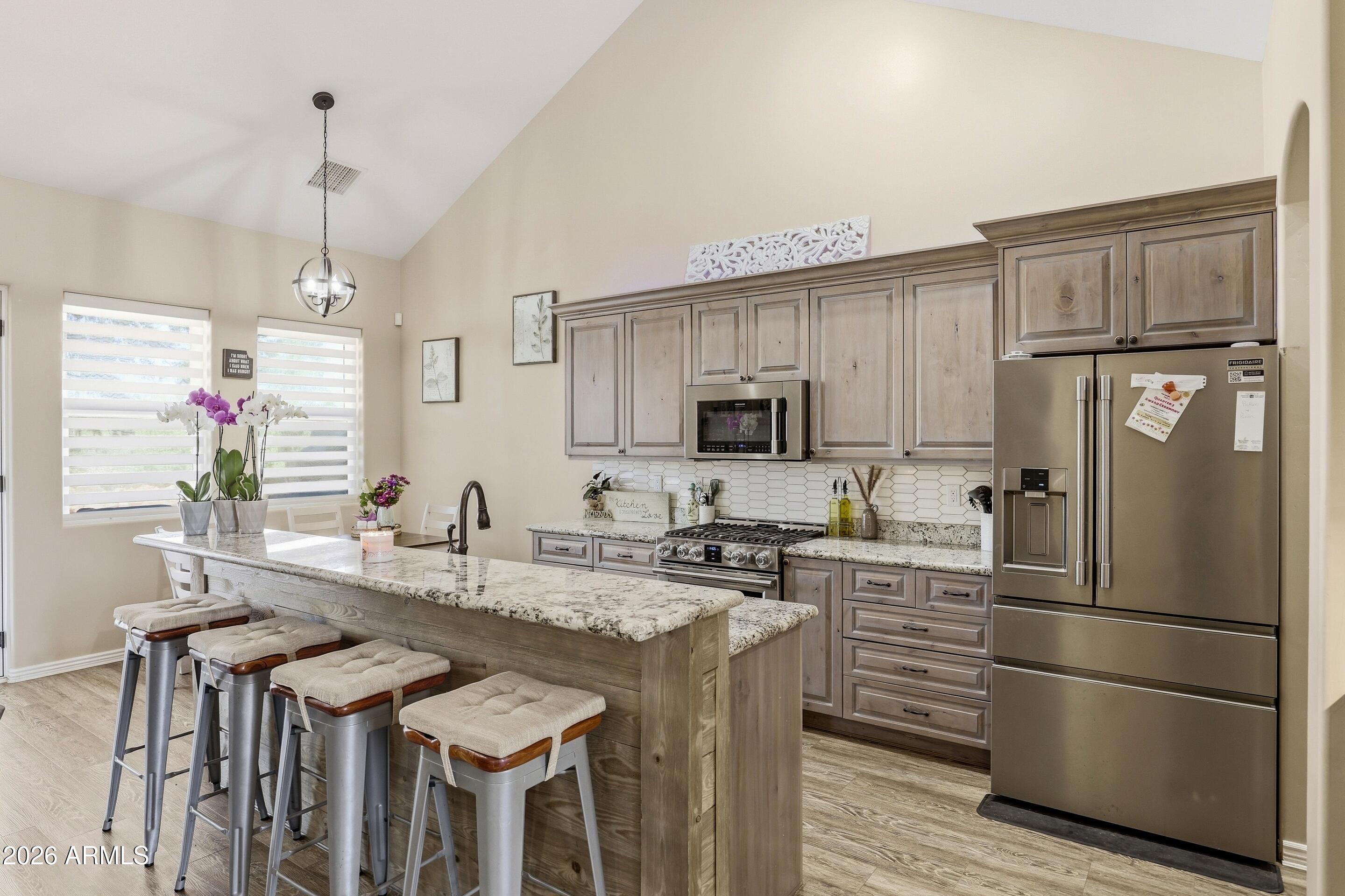 1206 East Bolivar Street Payson, AZ 85541 - Photo 5 of 43 a kitchen with stainless steel appliances granite countertop a refrigerator a stove a sink dishwasher and white cabinets with wooden floor