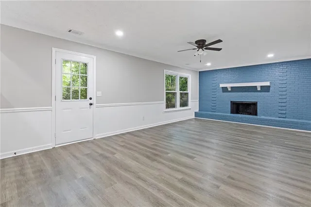 an empty room with windows and a ceiling fan