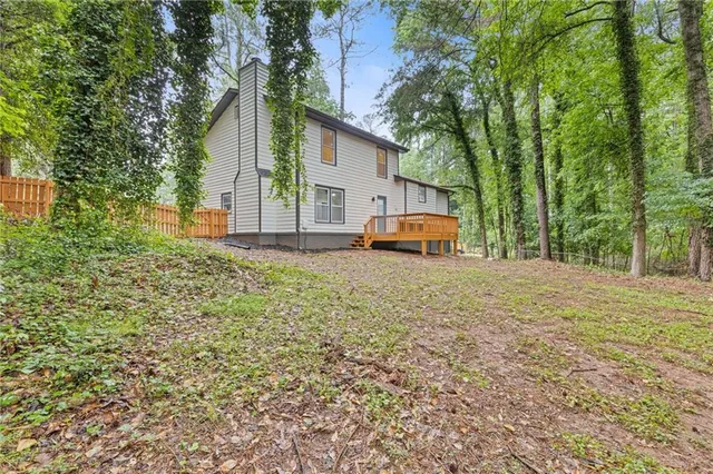 a view of a house with backyard and trees