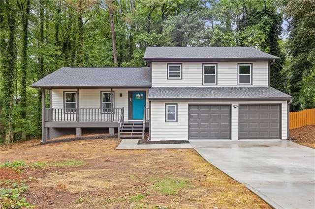 a front view of a house with a garden and yard