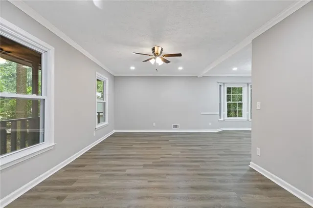 a view of a room with a ceiling fan and window