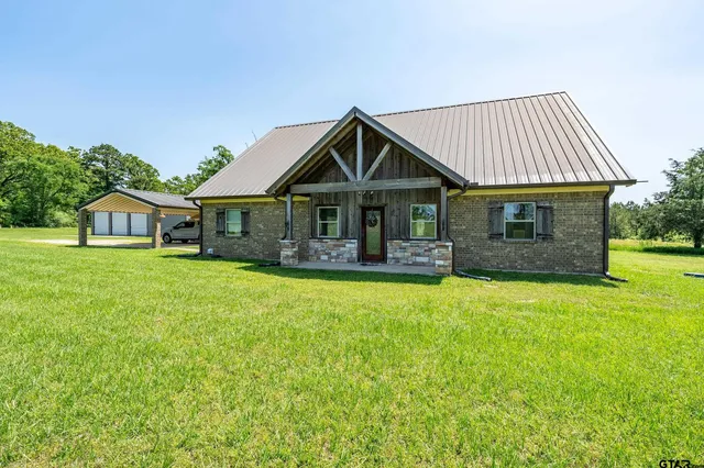a front view of a house with yard and porch
