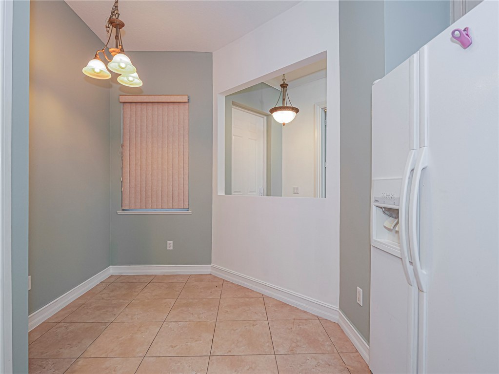 1835 Bridgepointe Circle, Unit 18 Vero Beach, FL 32967 - Photo 12 of 34 a view of an empty room with window and chandelier fan