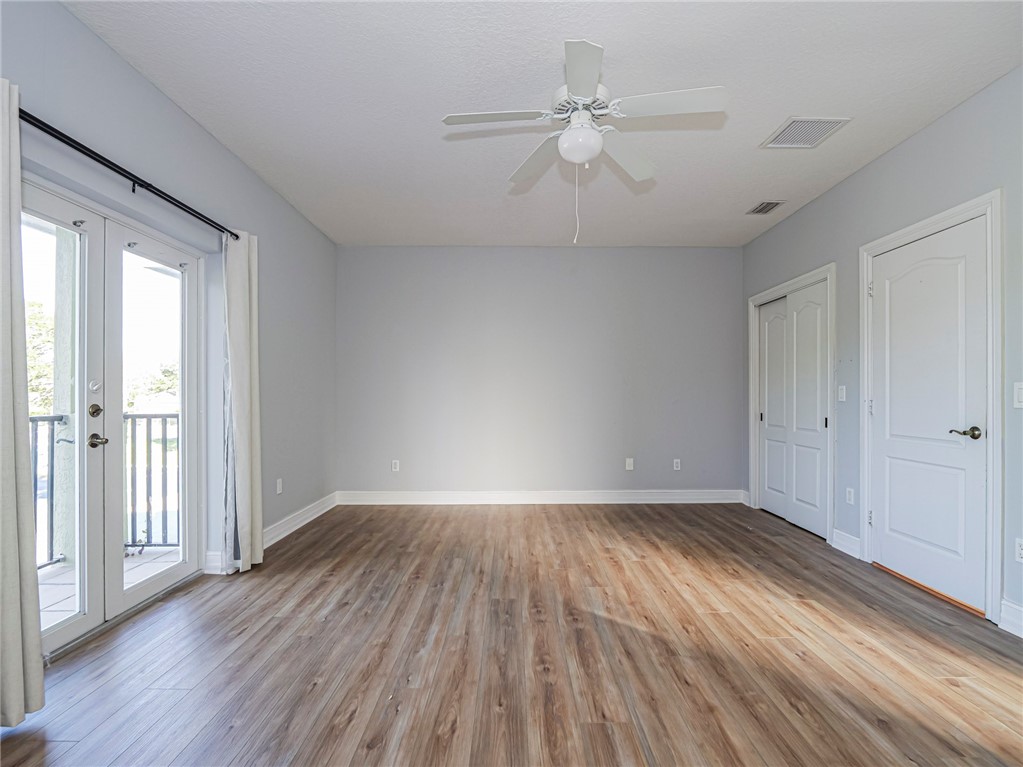 1835 Bridgepointe Circle, Unit 18 Vero Beach, FL 32967 - Photo 20 of 34 a view of an empty room with wooden floor and a window