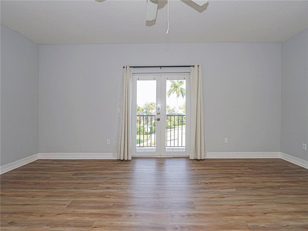 1835 Bridgepointe Circle, Unit 18 Vero Beach, FL 32967 - Photo 21 of 34 a view of an empty room with wooden floor and a window