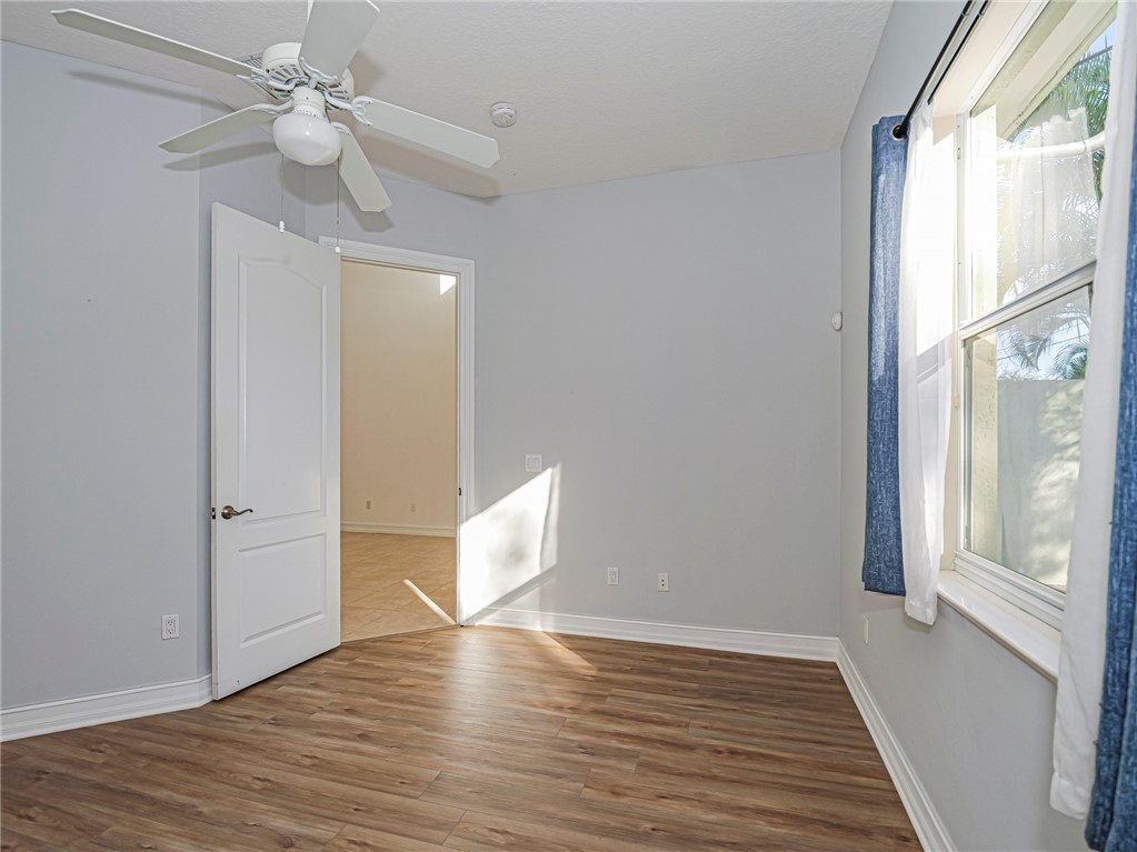 1835 Bridgepointe Circle, Unit 18 Vero Beach, FL 32967 - Photo 23 of 34 a view of an empty room with wooden floor and a window