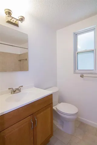 a bathroom with a sink a toilet and a mirror