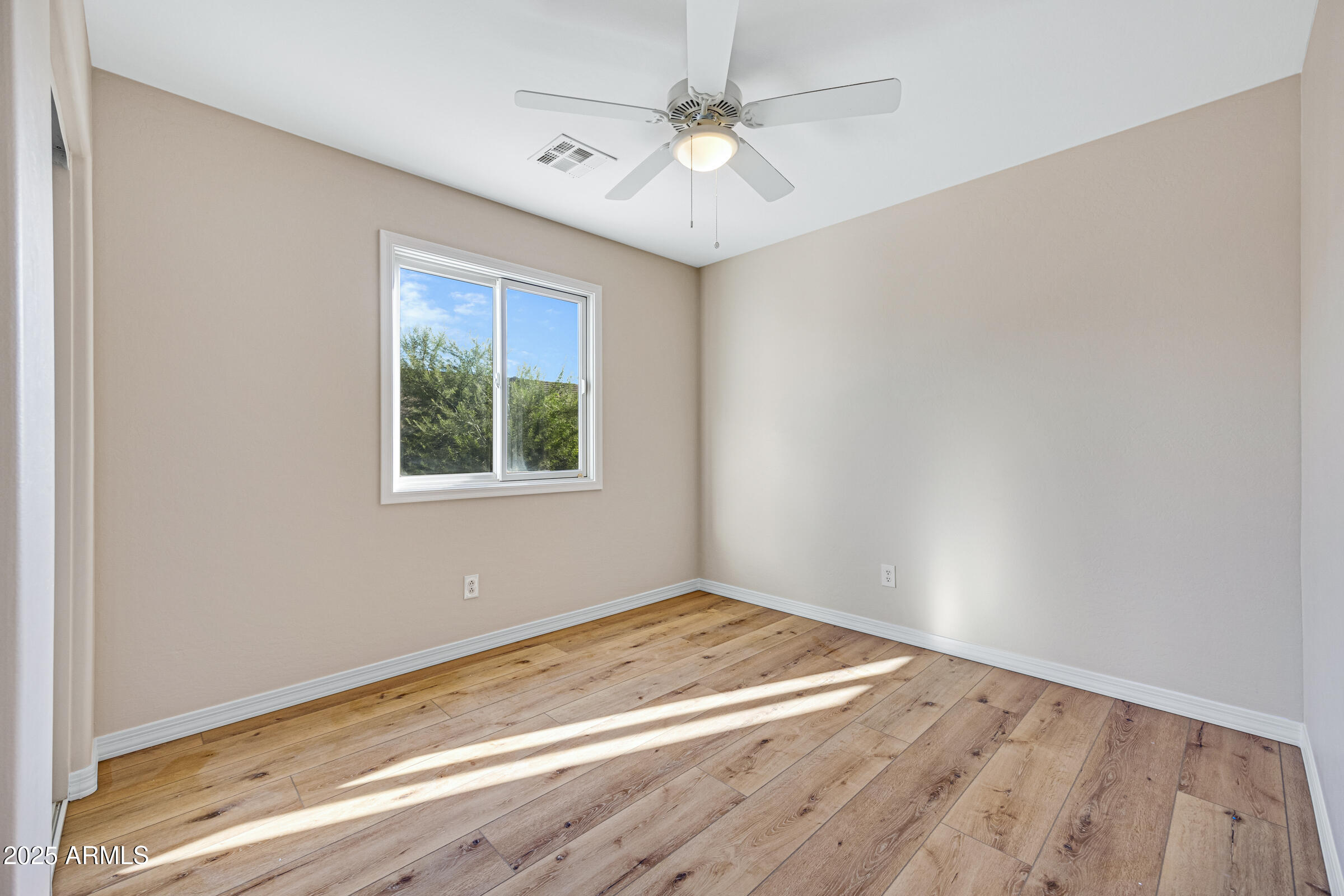 2315 East Pecan Road Phoenix, AZ 85040 - Photo 25 of 36 an empty room with a window and a ceiling fan