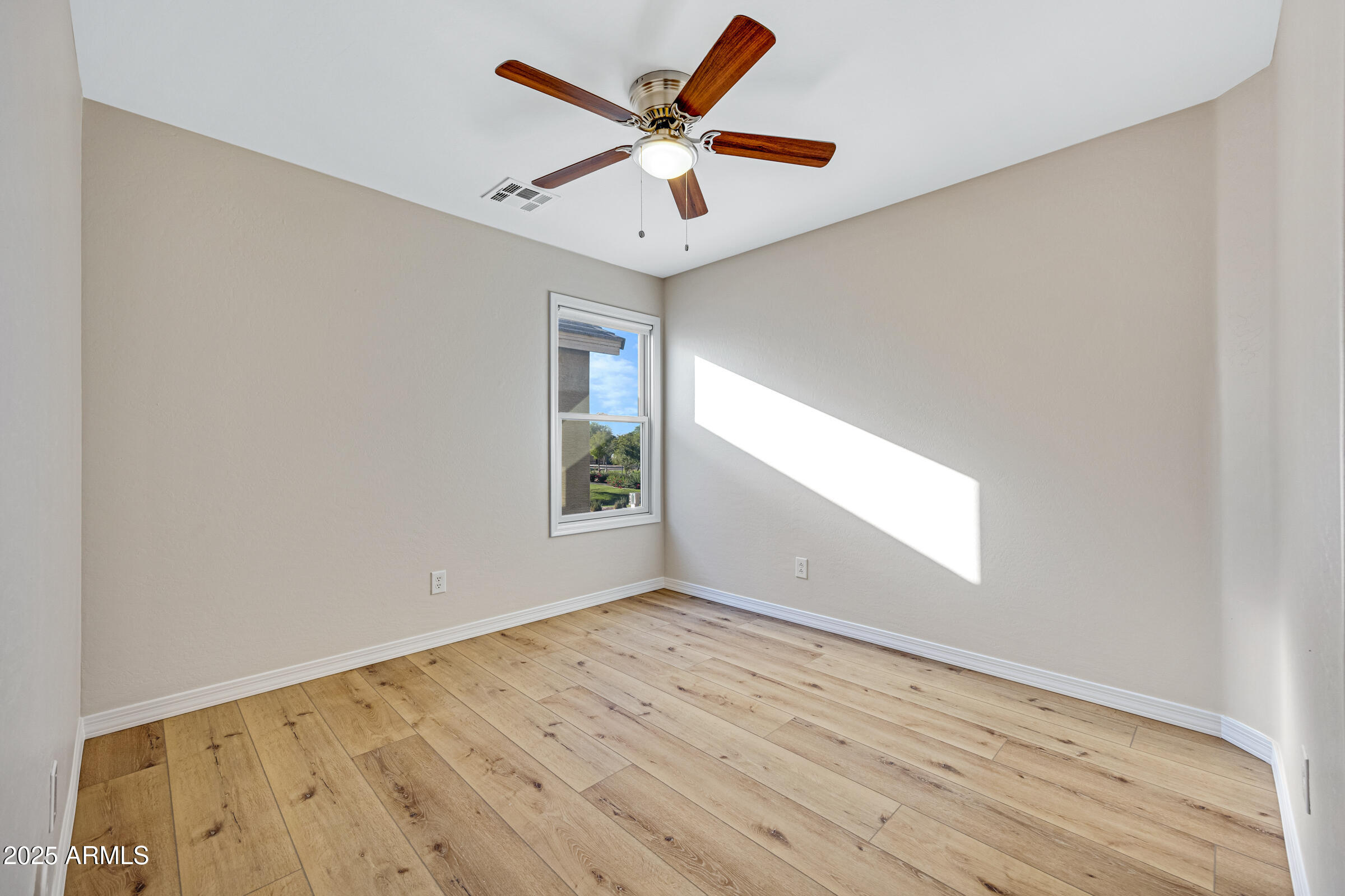 2315 East Pecan Road Phoenix, AZ 85040 - Photo 26 of 36 an empty room with wooden floor and windows