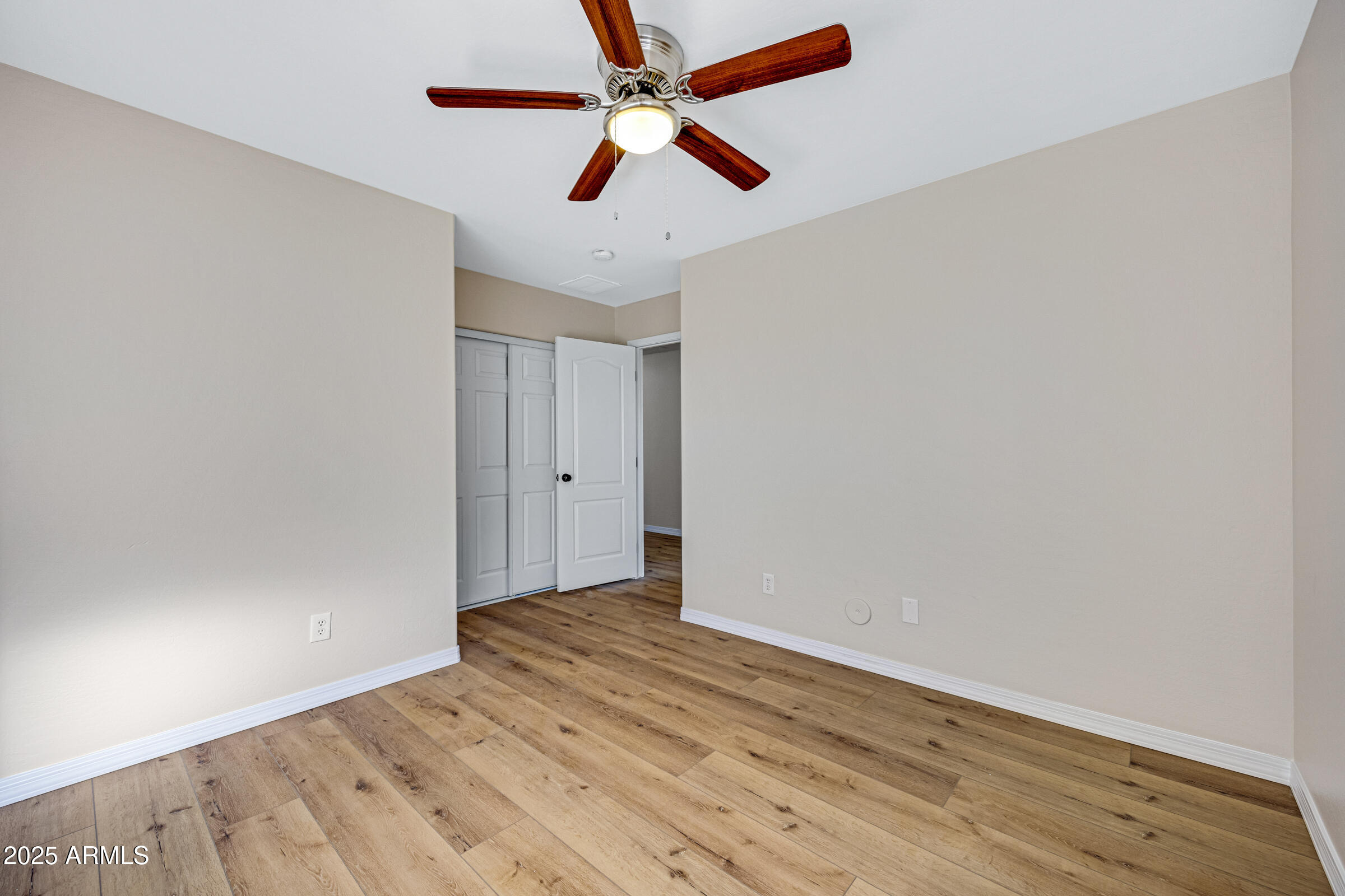 2315 East Pecan Road Phoenix, AZ 85040 - Photo 27 of 36 an empty room with wooden floor ceiling fan and window