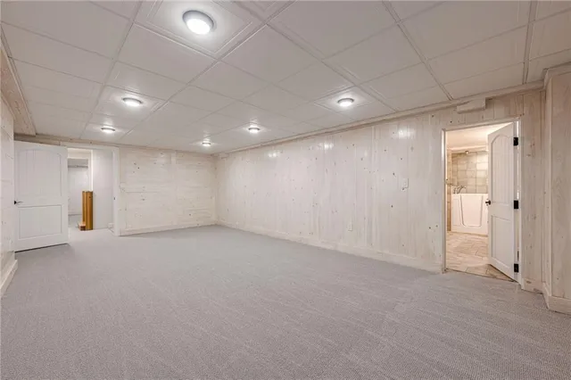 a view of an empty room with wooden floor and window