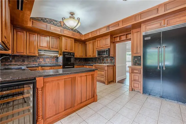 a kitchen with kitchen island granite countertop a stove cabinets and refrigerator
