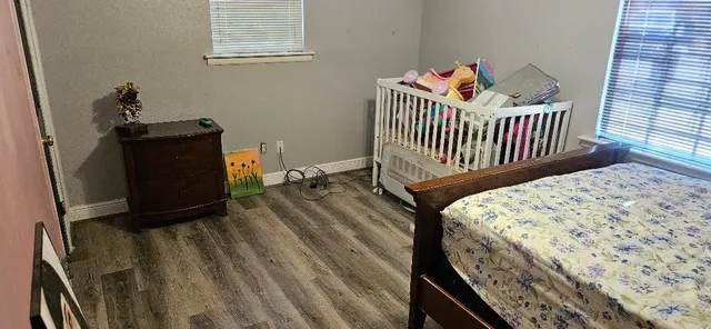 a bedroom with a bed and wooden floor