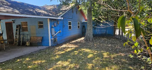 a view of a house with a small yard and wooden fence