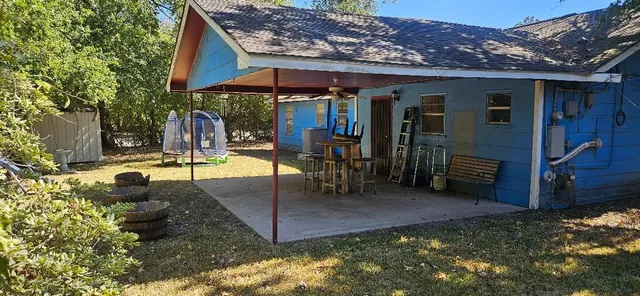 a view of a backyard with table and chairs under an umbrella