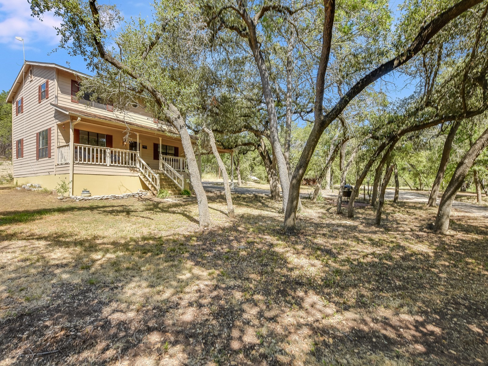 13404 Cedar Lime Road Leander, TX 78641 - Photo 8 of 28 A welcoming home with a covered front porch, nestled among mature trees on a spacious lot.