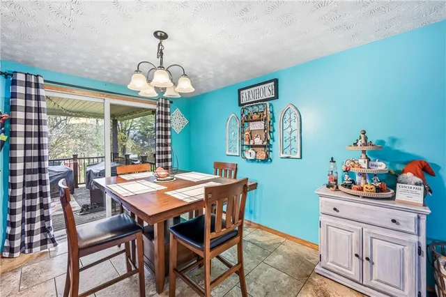 a dining room with wooden floor a chandelier a wooden table and chairs