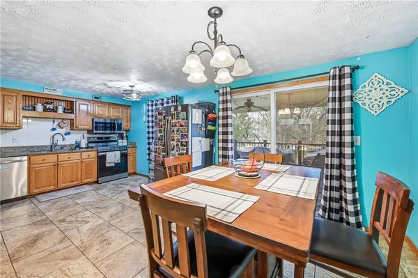 a view of a dining room with furniture a chandelier and wooden floor