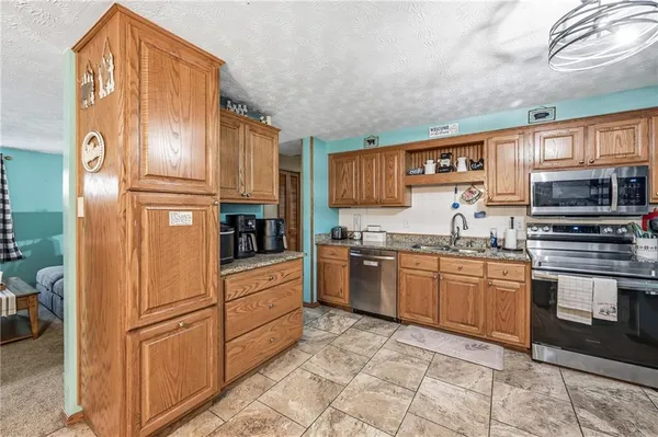 a kitchen with stainless steel appliances granite countertop a refrigerator and a stove top oven