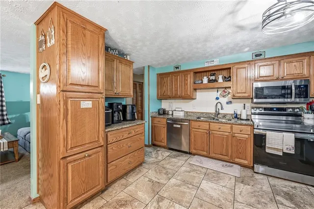 a kitchen with stainless steel appliances granite countertop a refrigerator and a stove top oven