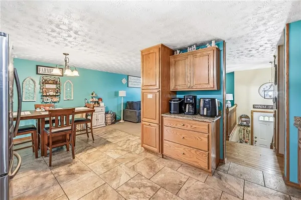 a kitchen with stainless steel appliances kitchen island granite countertop a refrigerator and cabinets